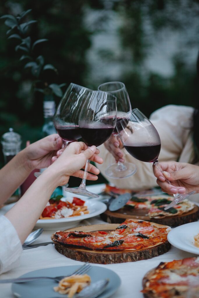 Adults having a wine and pizza night together.